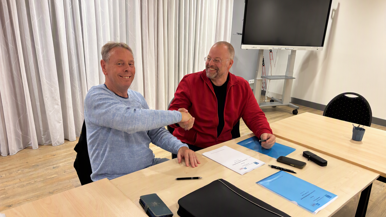Links Niek Stam, bestuurder van FNV Havens schudt de hand van Wouter Joosten, directeur-bestuurder van De Maasveren over het cao-akkoord.