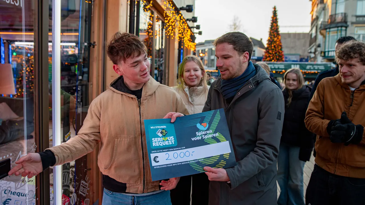 Dtv-verslaggever Dylan Jagers doet de cheque in de bus in het Glazen Huis.