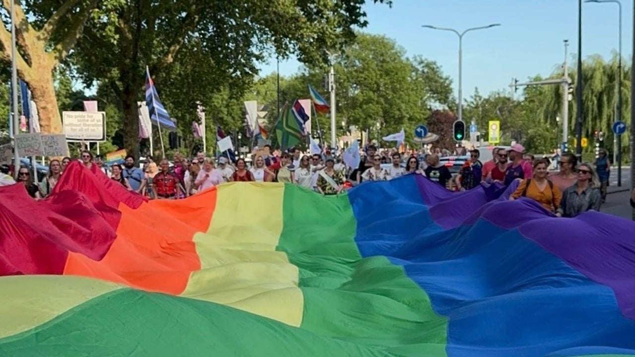 De enorme regenboogvlag aan het eindpunt van de Pride Walk